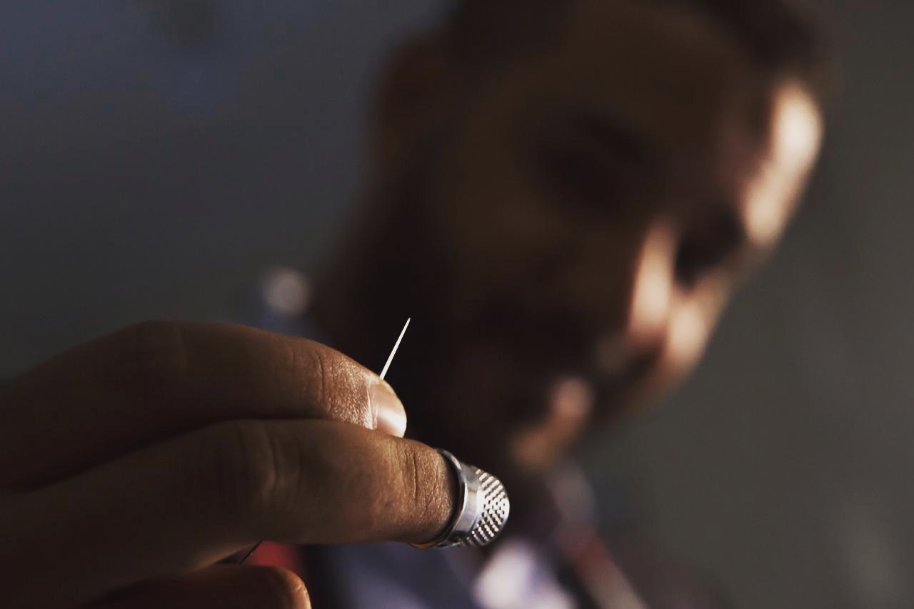 Close-up of needle and thimble during hand-stitching