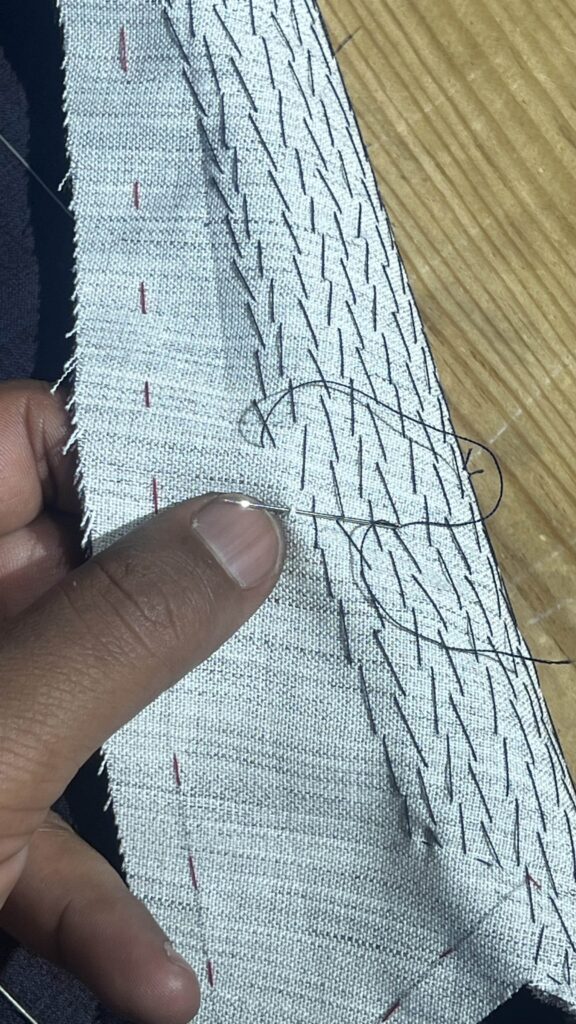 article / art of the canvas Close-up of hand pad-stitching with black thread on a floating canvas at Krarim Bespoke